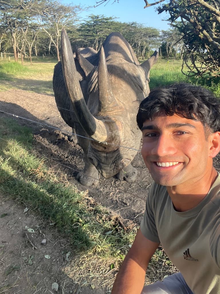 Amar taking a selfie near a rhino on safari