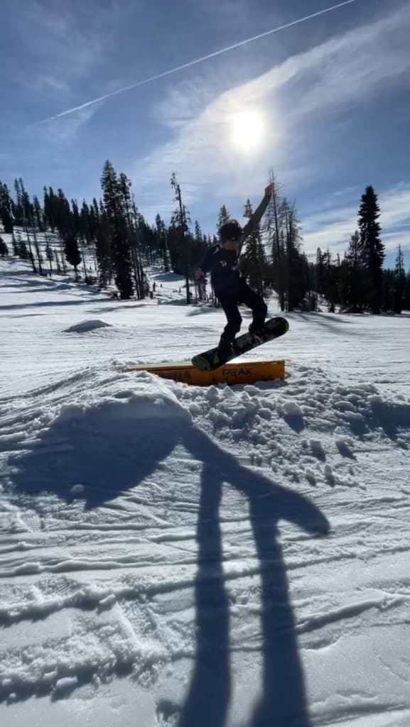 Amar snowboarding off a rail at a ski resort