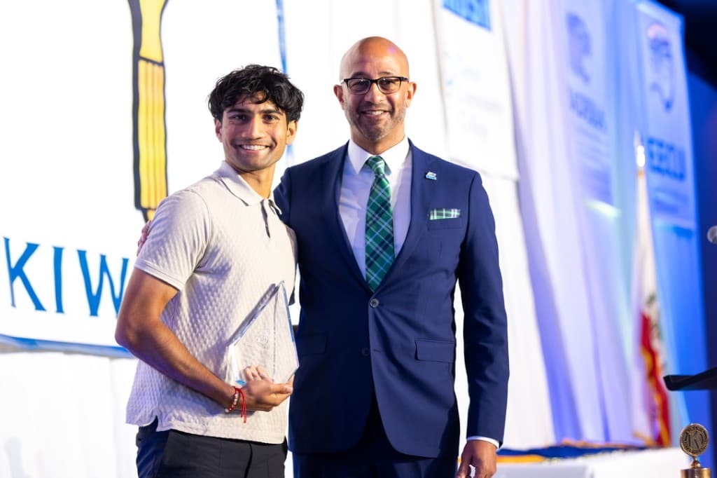 Amar receiving an award with a mentor at a Kiwanis ceremony
