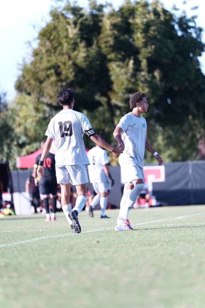 Soccer teammates exchanging a handshake on the field